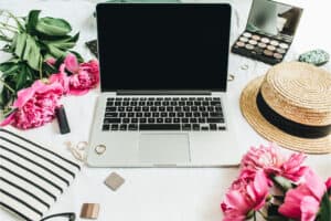 Sign up for newsletter, image of a computer with flowers and summery hat and makeup